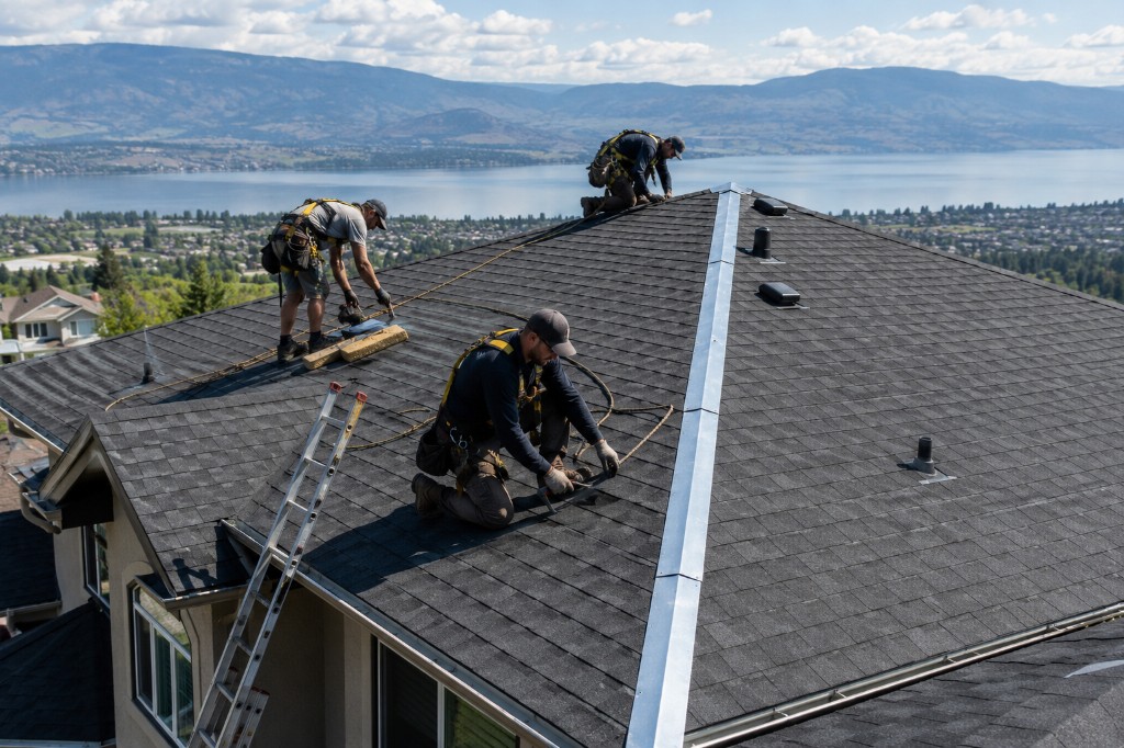 GAF-certified roofing crew installing architectural asphalt shingles on Okanagan home overlooking lake and mountains with safety harnesses and ladder